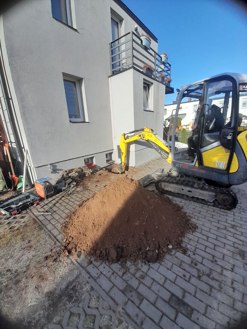 Odkrywka fundamentu przy budynku — minikoparka