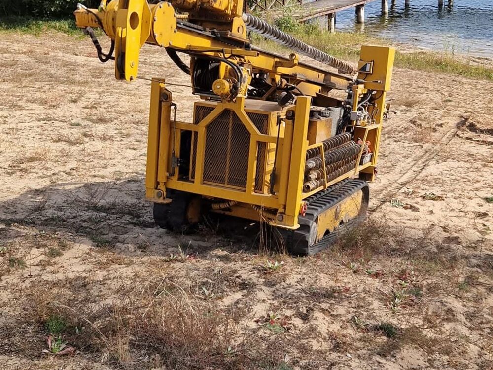 Wiertnica gąsienicowa podczas odwiertów geologicznych nad jeziorem